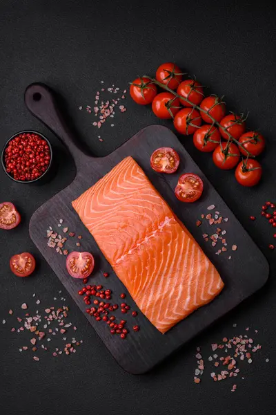 stock image Fresh raw salmon red fish fillet with salt and spices on a dark concrete background