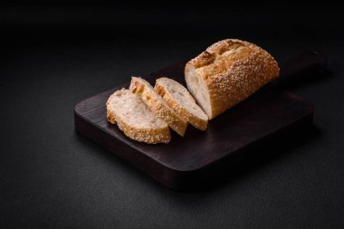 Tahta kesme tahtasının üzerinde susam tohumlu buğday unlu baget.