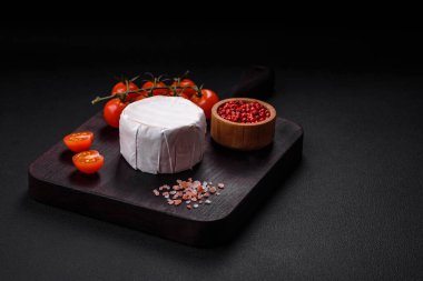 Koyu beton arka planda kiraz domatesli mini kafa şeklinde leziz taze brie peyniri.