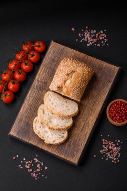 Tahta kesme tahtasının üzerinde susam tohumlu buğday unlu baget.