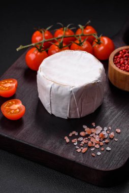 Koyu beton arka planda kiraz domatesli mini kafa şeklinde leziz taze brie peyniri.