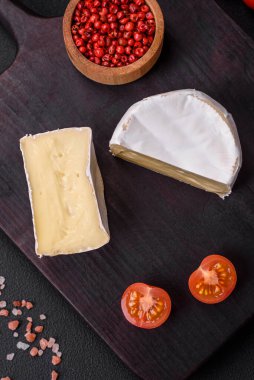 Koyu beton arka planda kiraz domatesli mini kafa şeklinde leziz taze brie peyniri.