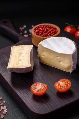 Koyu beton arka planda kiraz domatesli mini kafa şeklinde leziz taze brie peyniri.