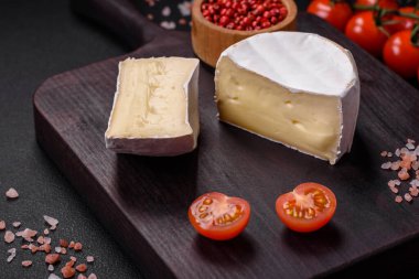 Koyu beton arka planda kiraz domatesli mini kafa şeklinde leziz taze brie peyniri.