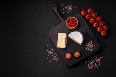 Koyu beton arka planda kiraz domatesli mini kafa şeklinde leziz taze brie peyniri.