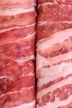 Pastırmaya sarılmış tuzlu ve baharatlı çiğ et veya koyu beton arka planda cevapcici.