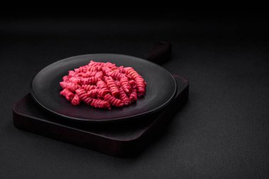 Beton arka planda pancar pesto, parmesan, tuz ve baharatlı lezzetli fusilli makarna.