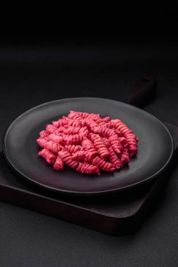 Beton arka planda pancar pesto, parmesan, tuz ve baharatlı lezzetli fusilli makarna.