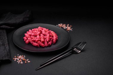 Beton arka planda pancar pesto, parmesan, tuz ve baharatlı lezzetli fusilli makarna.