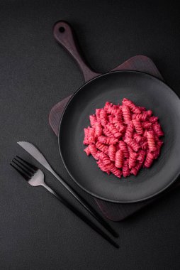 Beton arka planda pancar pesto, parmesan, tuz ve baharatlı lezzetli fusilli makarna.