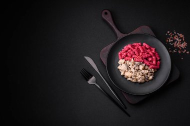 Beton arka planda pancar pesto, parmesan, tuz ve baharatlı lezzetli fusilli makarna.