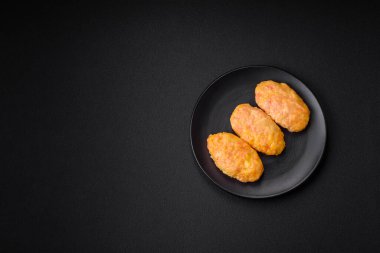 Koyu beton zeminde havuç, peynir, tuz ve baharatlı lezzetli buhar pirzolaları.