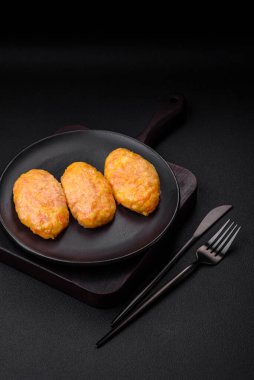 Koyu beton zeminde havuç, peynir, tuz ve baharatlı lezzetli buhar pirzolaları.