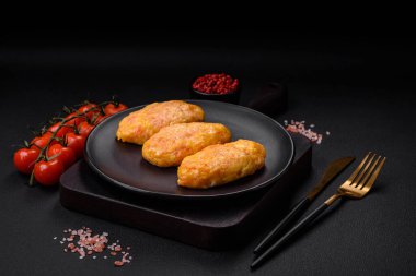 Koyu beton zeminde havuç, peynir, tuz ve baharatlı lezzetli buhar pirzolaları.