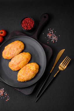 Koyu beton zeminde havuç, peynir, tuz ve baharatlı lezzetli buhar pirzolaları.