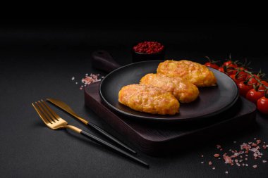 Koyu beton zeminde havuç, peynir, tuz ve baharatlı lezzetli buhar pirzolaları.