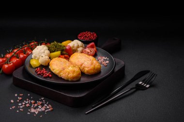 Koyu beton zeminde havuç, peynir, tuz ve baharatlı lezzetli buhar pirzolaları.