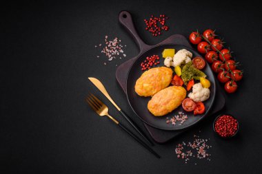 Koyu beton zeminde havuç, peynir, tuz ve baharatlı lezzetli buhar pirzolaları.