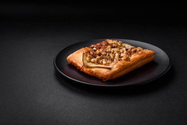 Lezzetli taze turta ya da armut, peynir, bal ve fındıklı koyu beton arka planda pizza.