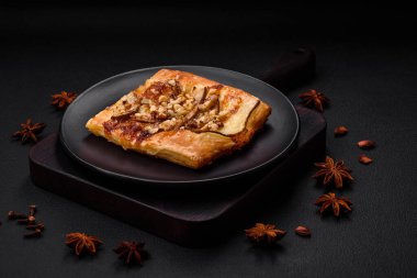 Lezzetli taze turta ya da armut, peynir, bal ve fındıklı koyu beton arka planda pizza.