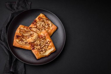 Lezzetli taze turta ya da armut, peynir, bal ve fındıklı koyu beton arka planda pizza.