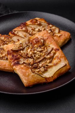 Lezzetli taze turta ya da armut, peynir, bal ve fındıklı koyu beton arka planda pizza.