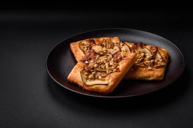 Lezzetli taze turta ya da armut, peynir, bal ve fındıklı koyu beton arka planda pizza.