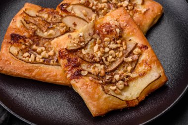 Lezzetli taze turta ya da armut, peynir, bal ve fındıklı koyu beton arka planda pizza.