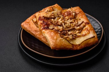 Lezzetli taze turta ya da armut, peynir, bal ve fındıklı koyu beton arka planda pizza.