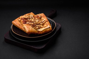 Lezzetli taze turta ya da armut, peynir, bal ve fındıklı koyu beton arka planda pizza.