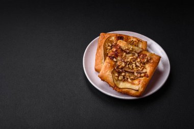 Lezzetli taze turta ya da armut, peynir, bal ve fındıklı koyu beton arka planda pizza.