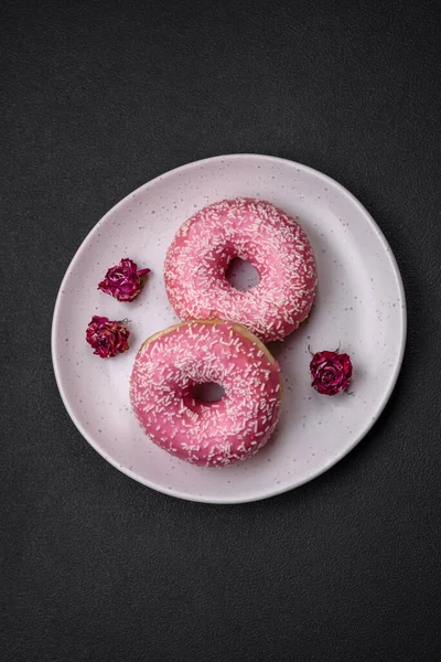 stock image Delicious fresh sweet donuts in pink glaze with strawberry filling on a dark concrete background