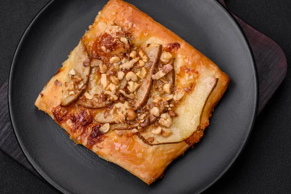 Lezzetli taze turta ya da armut, peynir, bal ve fındıklı koyu beton arka planda pizza.