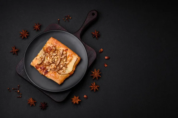 stock image Delicious fresh sweet pie or pizza with pear, brie cheese, honey and nuts on a dark concrete background