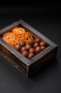 Lezzetli kavrulmuş macadamia fındıkları koyu desenli beton arka planda. Vejetaryen yemeği.