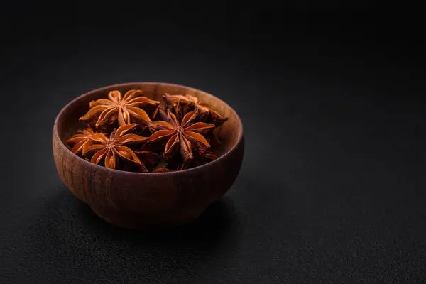 stock image Star shaped spice star anise in a wooden round bowl on a dark concrete background