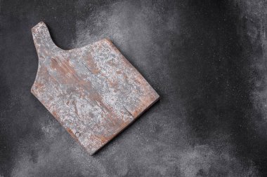 Koyu beton arka planda çatlaklar ve çizikler olan boş ahşap kesme tahtası