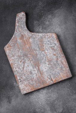 Koyu beton arka planda çatlaklar ve çizikler olan boş ahşap kesme tahtası
