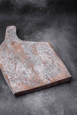 Koyu beton arka planda çatlaklar ve çizikler olan boş ahşap kesme tahtası