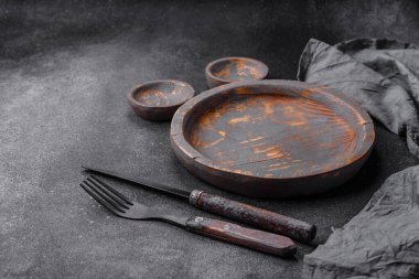 Boş ahşap tabak, bıçak, çatal ve kesme tahtası.