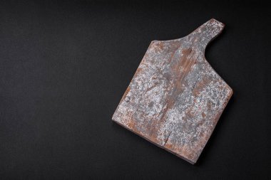 Koyu beton arka planda çatlaklar ve çizikler olan boş ahşap kesme tahtası