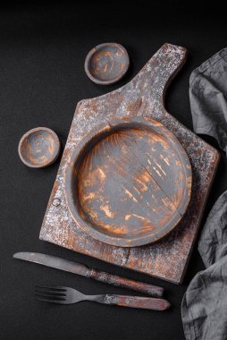 Boş ahşap tabak, bıçak, çatal ve kesme tahtası.