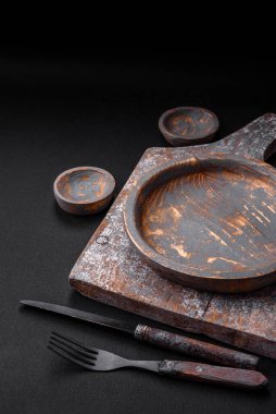 Boş ahşap tabak, bıçak, çatal ve kesme tahtası.
