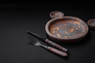 Boş ahşap tabak, bıçak, çatal ve kesme tahtası.