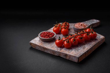 Bıçak, çatal ve kesim tahtası, tuz, biber ve diğer malzemeler desenli beton arka planda yer alıyor.