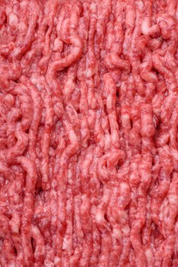 Ahşap kesme tahtasındaki çiğ et ya da domuz eti, baharatlar ve koyu beton arka planda tuz.