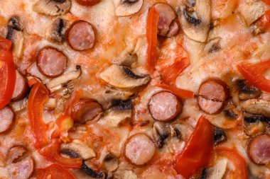 Füme sosisli Bavyera pizzası, domates, peynir, tuz ve baharatlar koyu beton arka planda.