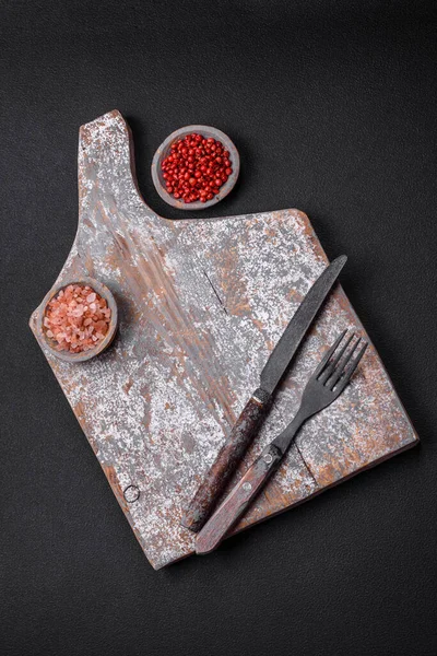 切菜刀 叉子和切菜板 胡椒和其他材料 位于混凝土结构的背景上 — 图库照片