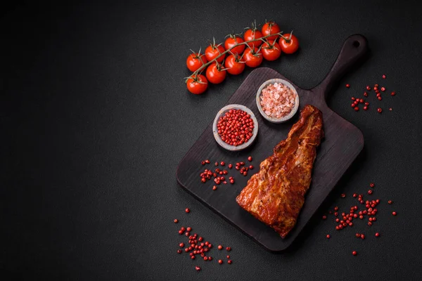 stock image Delicious grilled or smoked pork ribs with salt, spices and herbs on textured concrete background