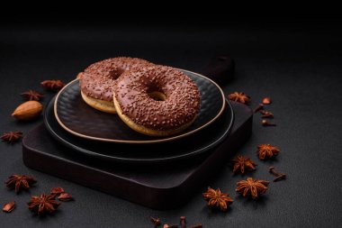 Koyu beton bir zemine çikolata parçacıkları serpiştirilmiş lezzetli çikolata kaplı donut.